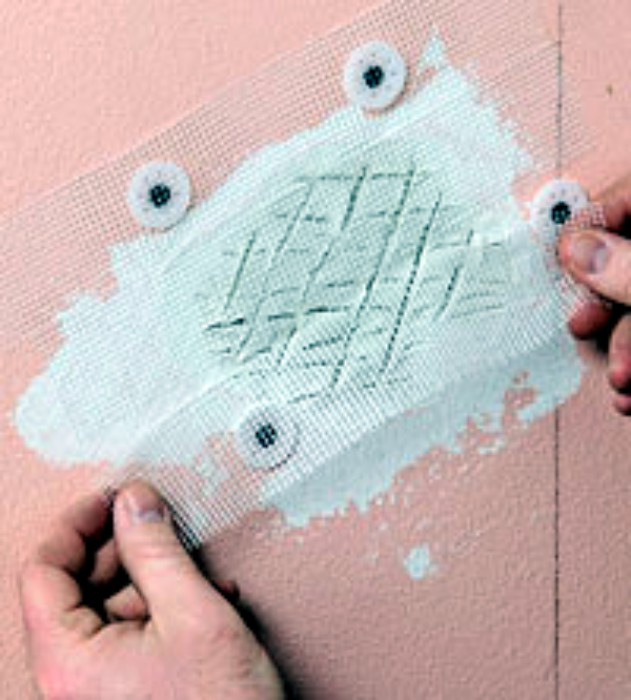 Filling in the hole with patching compound, scoring it, and placing fiberglass tape over. The entire repair is then skim coated. Photo:diyadvice.com.