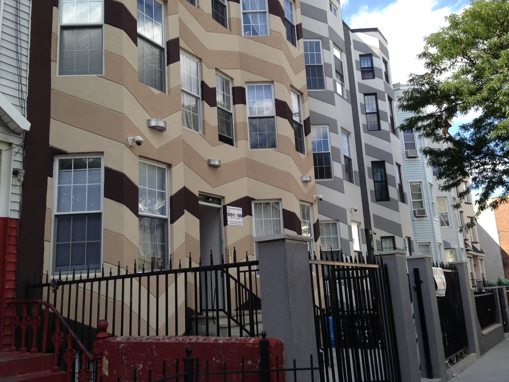 A group of wood frame houses on Cornelia Street in Bushwick with new stucco facades. Photo by Cate Corcoran