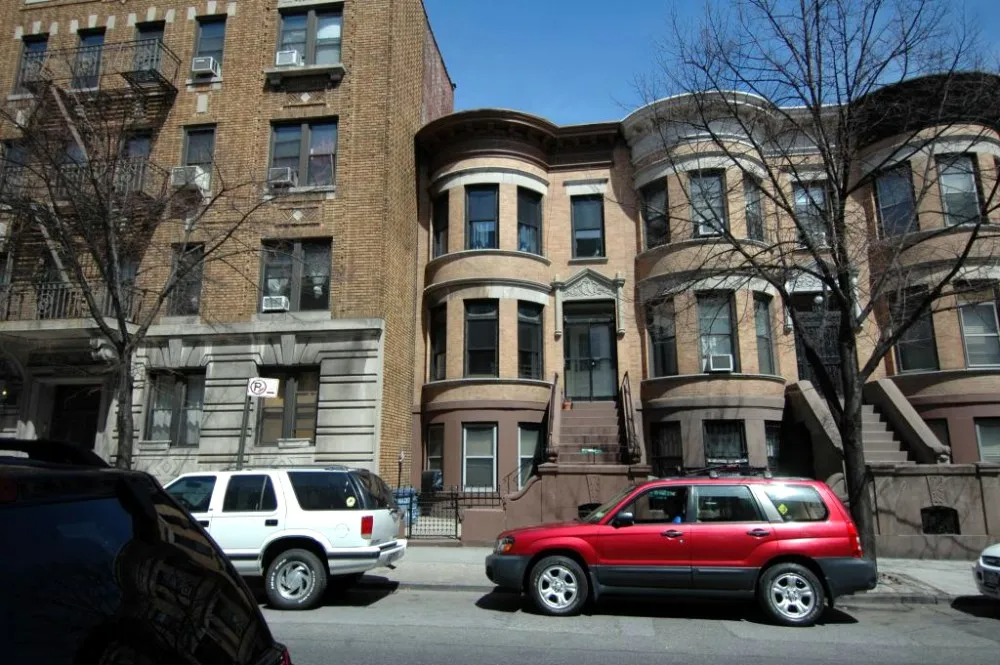 row house with red car parked in front