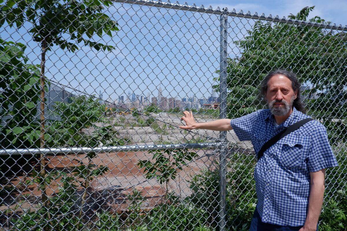 Steve Chesler, co-founder of Friends of Bushwick Inlet Park, stands outside a gated lot at Kent Avenue and N. 12th Street