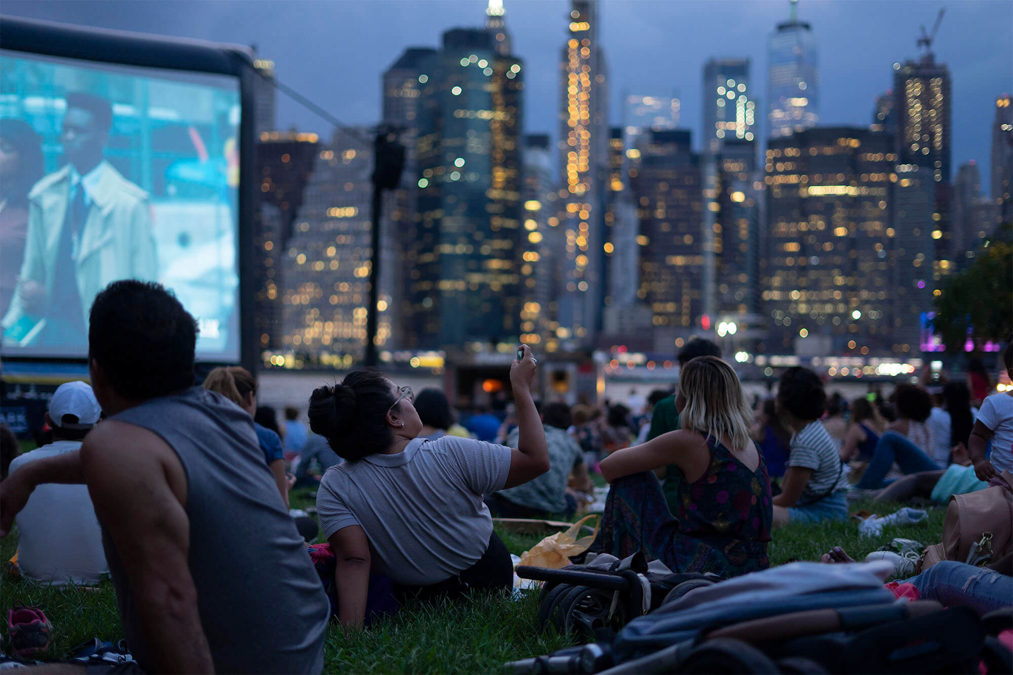 people watching a movie outdoors in brooklyn bridge park