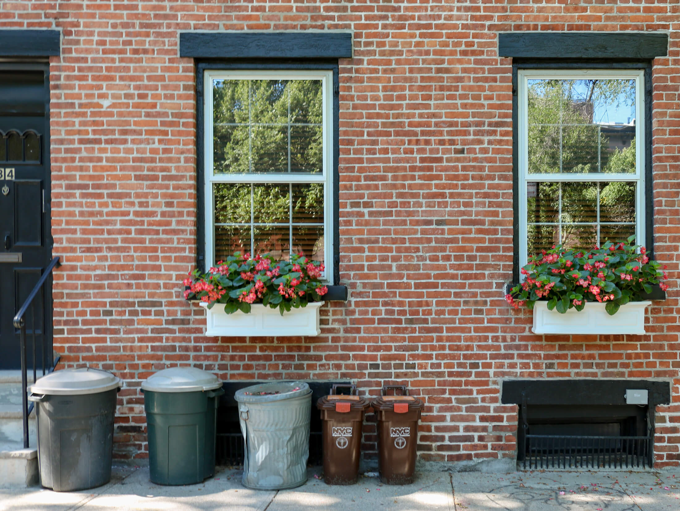 garbage and recycling cans outside a house