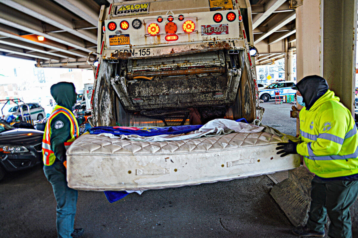 workers tossing a mattress