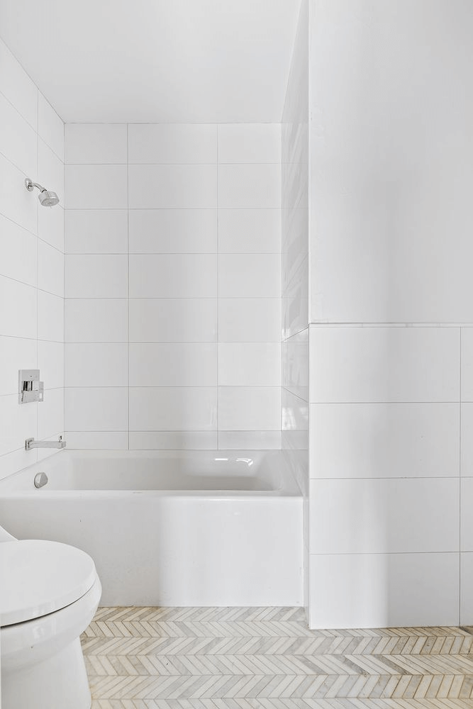 bath with white tiles and fixtures