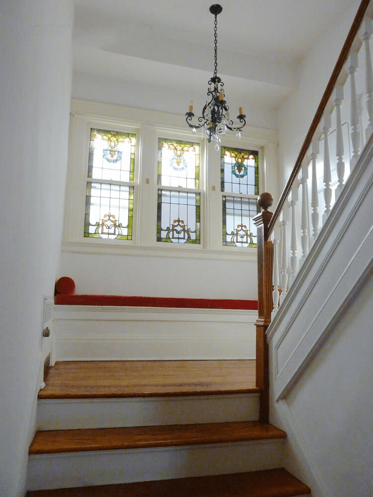 stair landing with stained glass windows in 1225 ditmas park