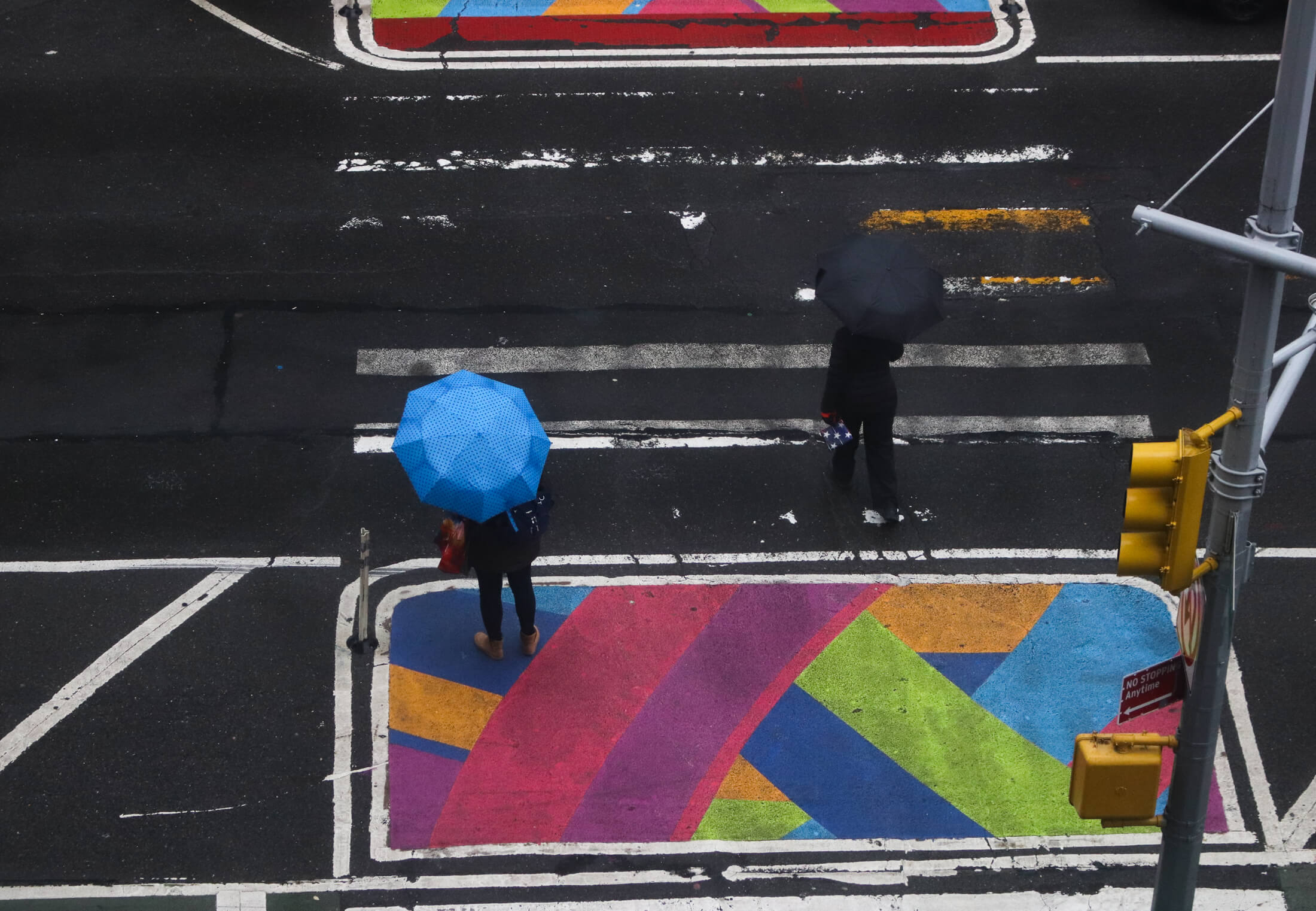 people walking across jay street with umbrellas in downtown brooklyn