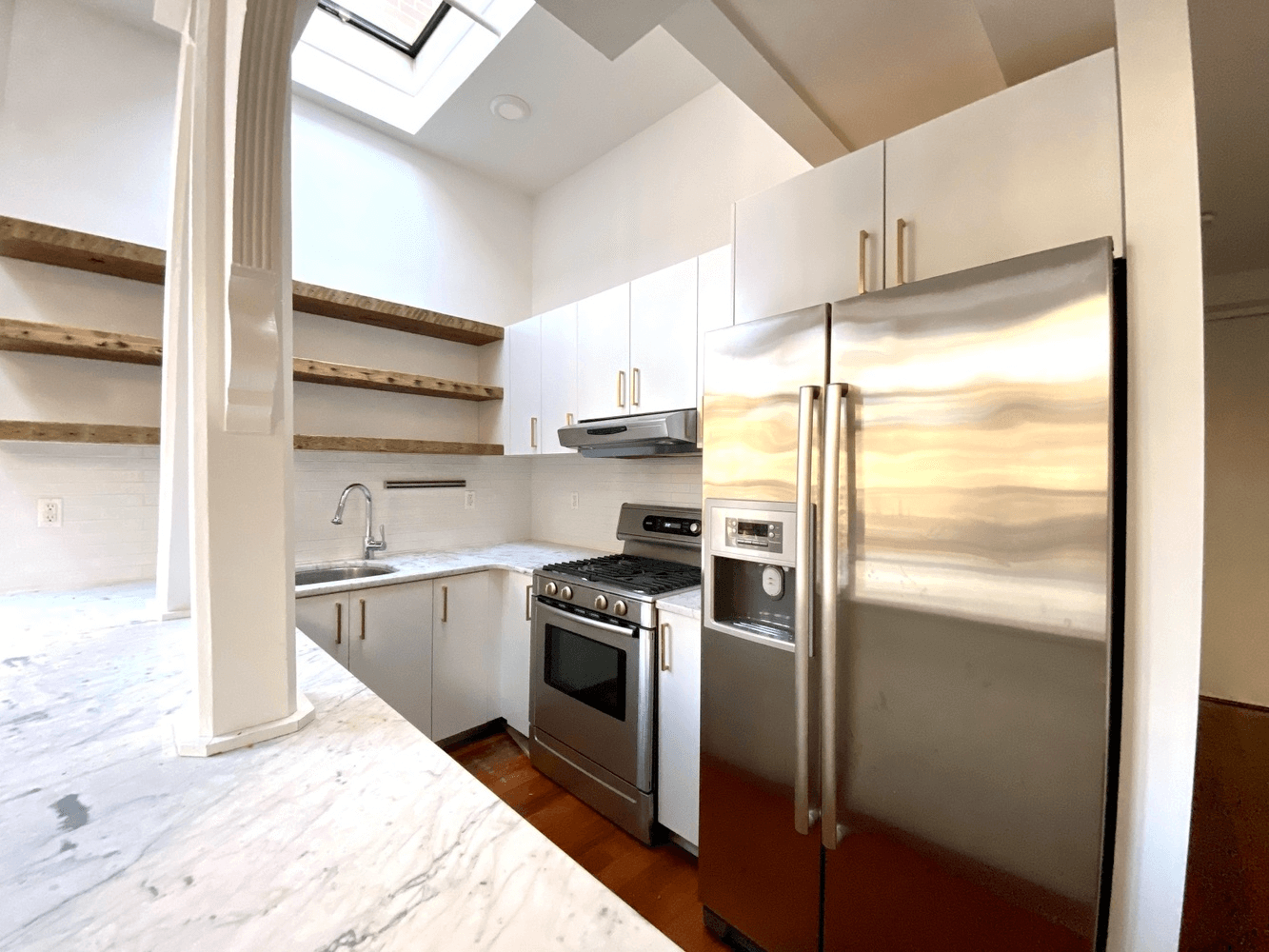 kitchen with skylight and white cabinets