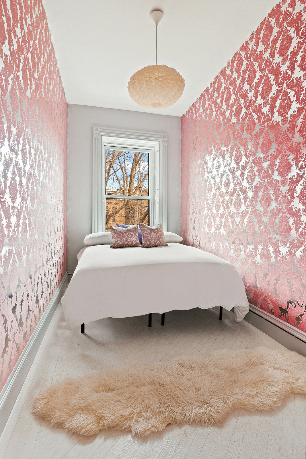 small bedroom with pink wallpaper