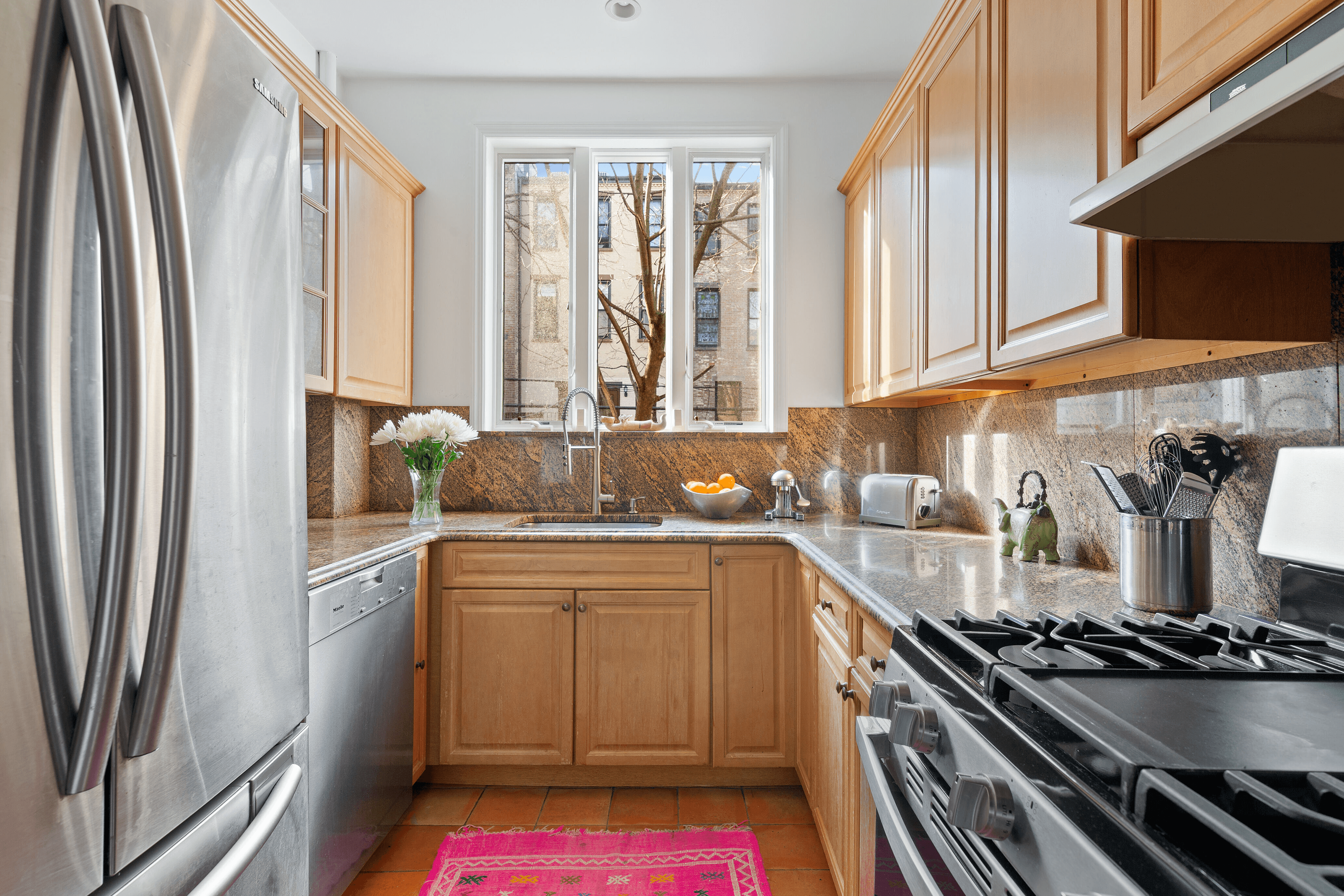 kitchen with pale wood cabinets and stainless steel appliances