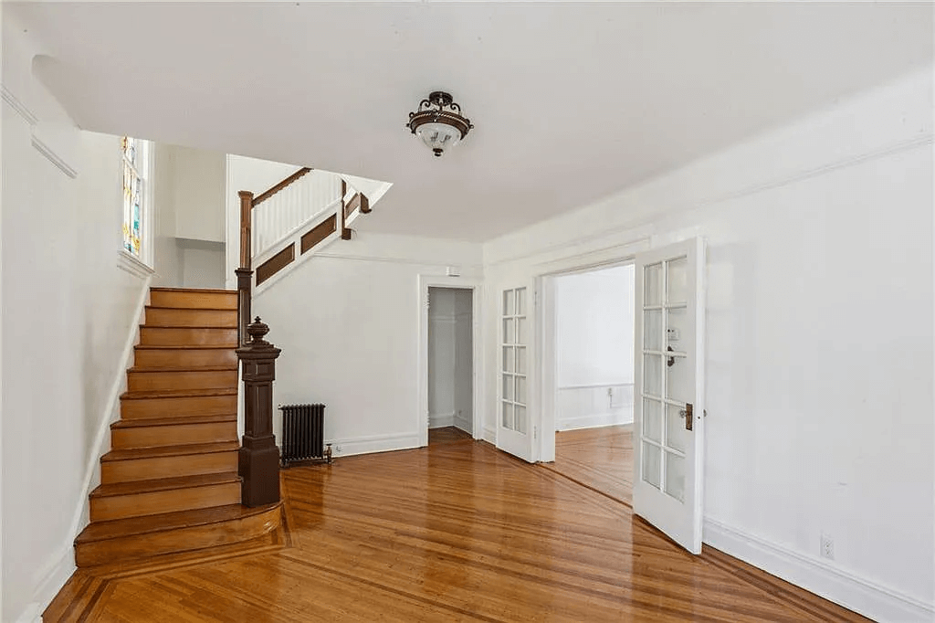 entry with original stair and stained glass window in 761 east 22nd street