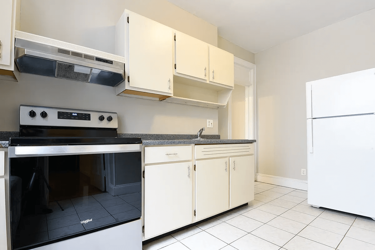 kitchen with white cabinets, white fridge and stainless steel stove