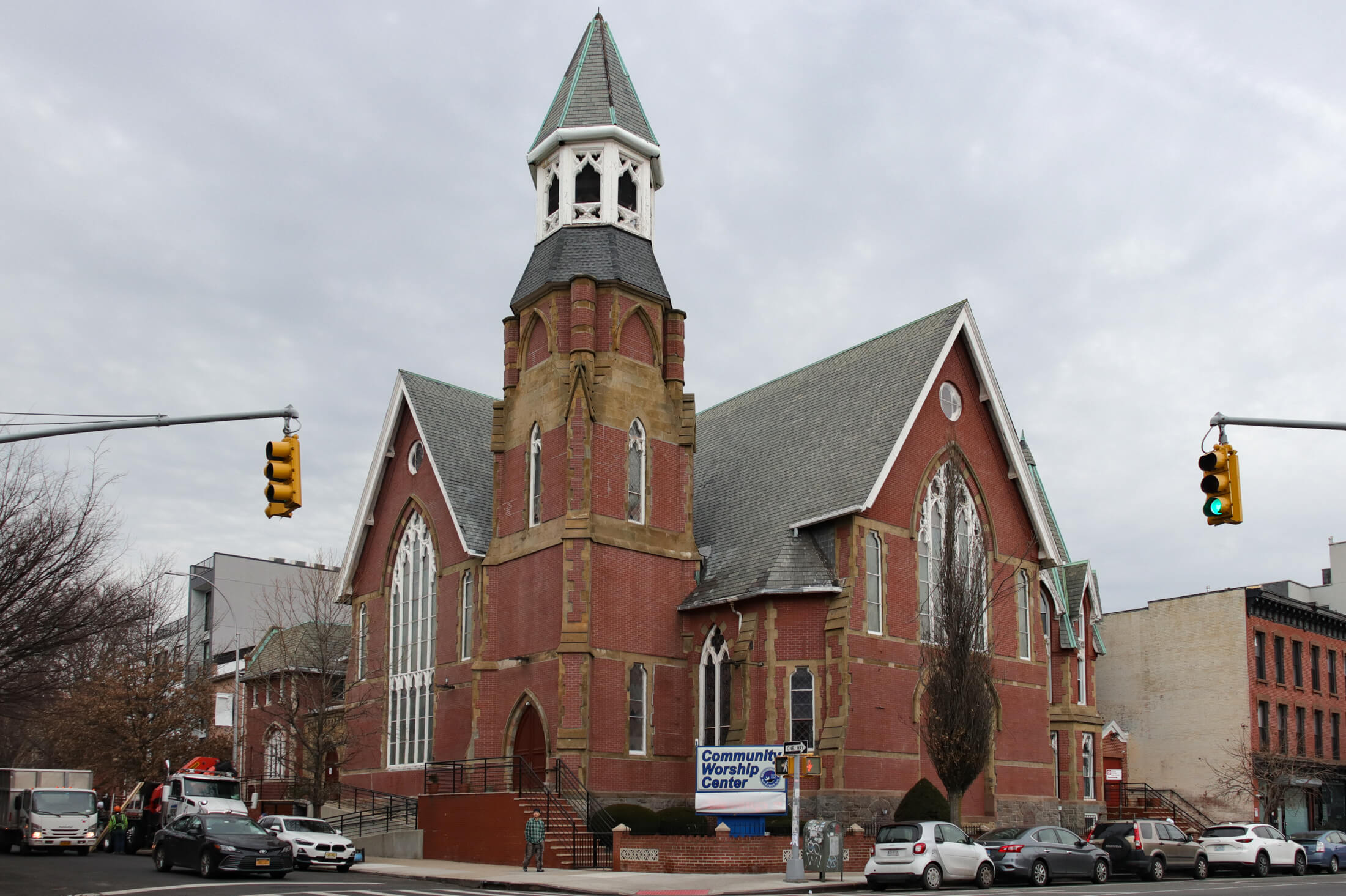 a pedestrian walking in front of a church in bed stuy