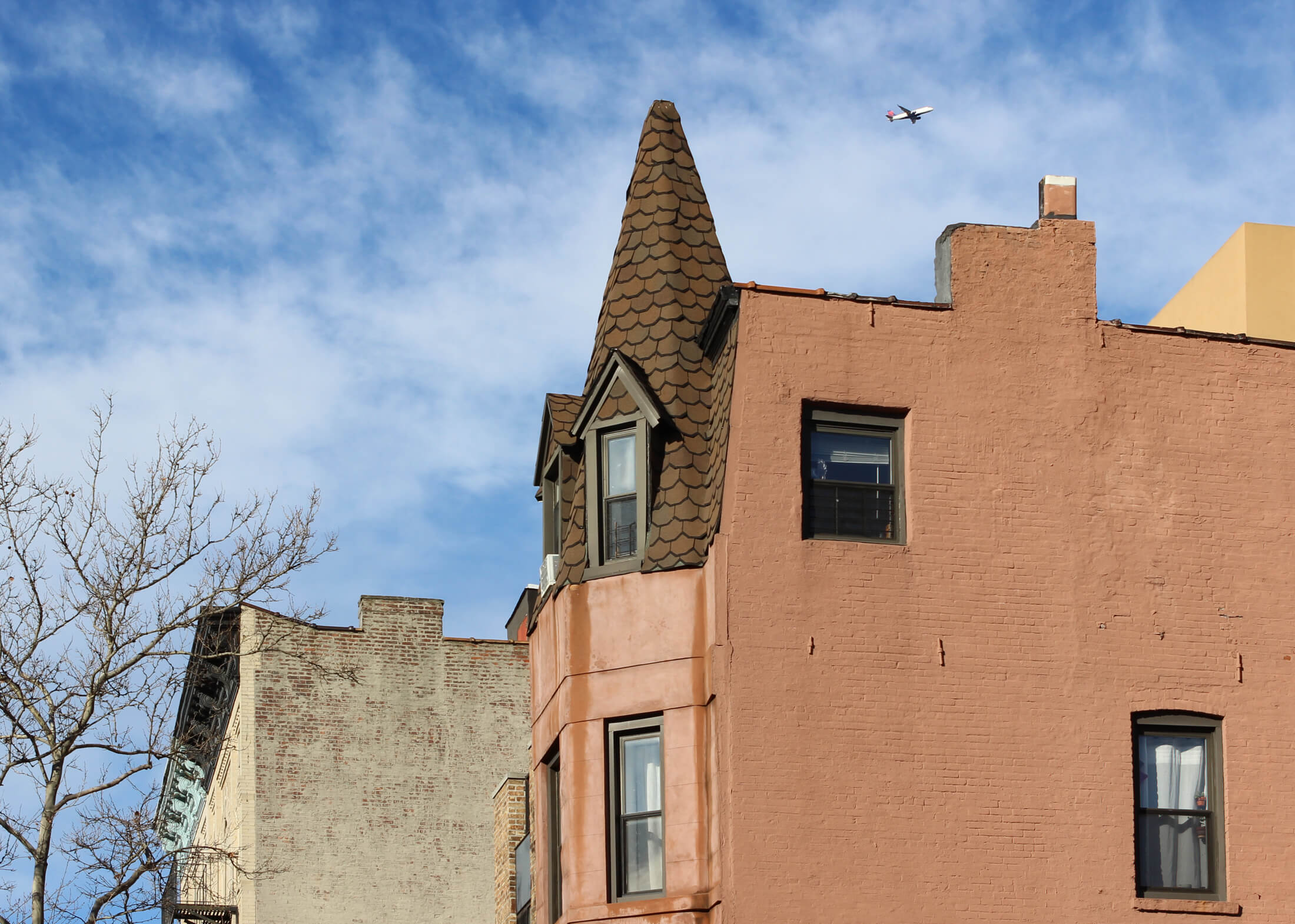 a plane flying over houses in bed stuy