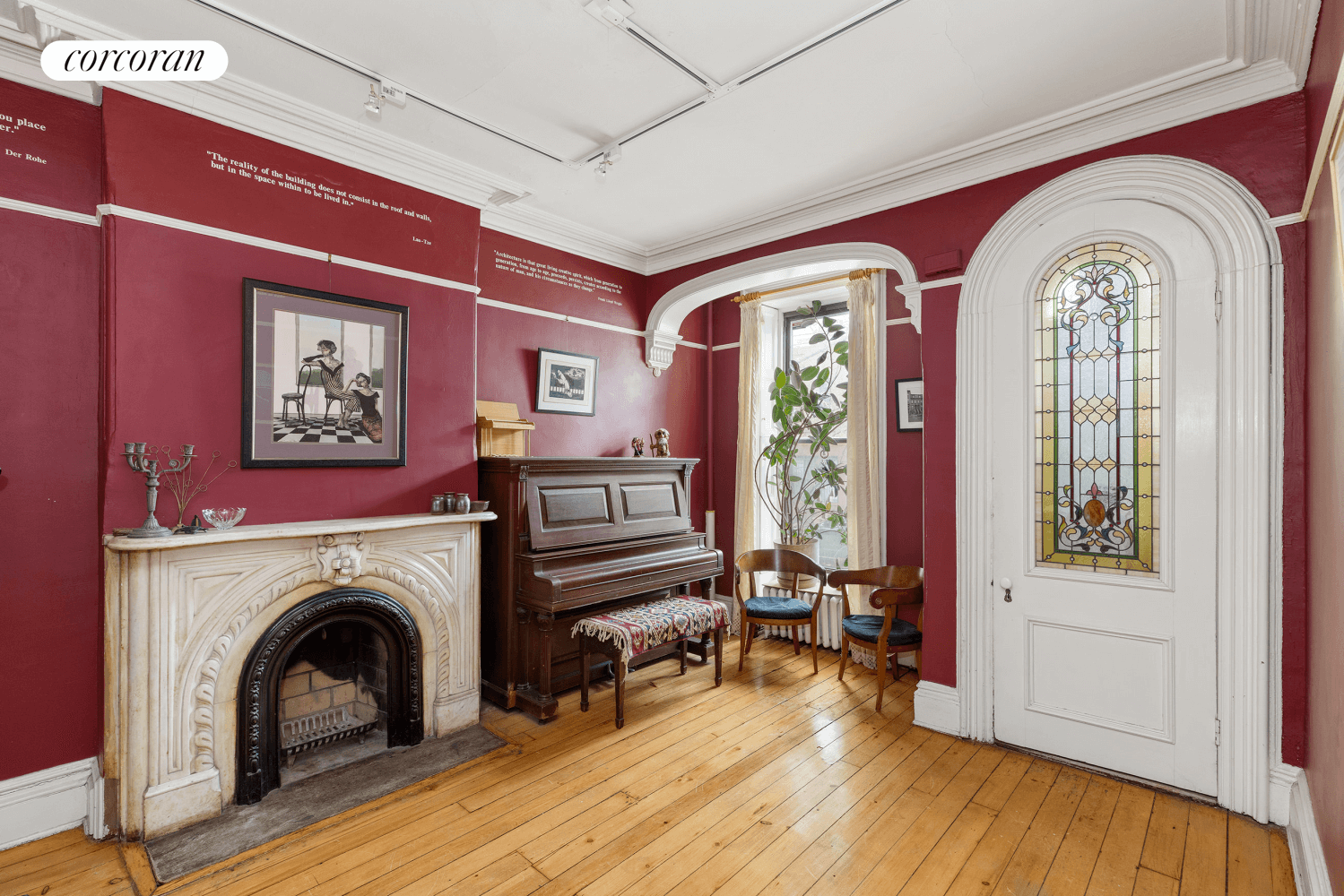 front parlor with marble mantel and arched front door