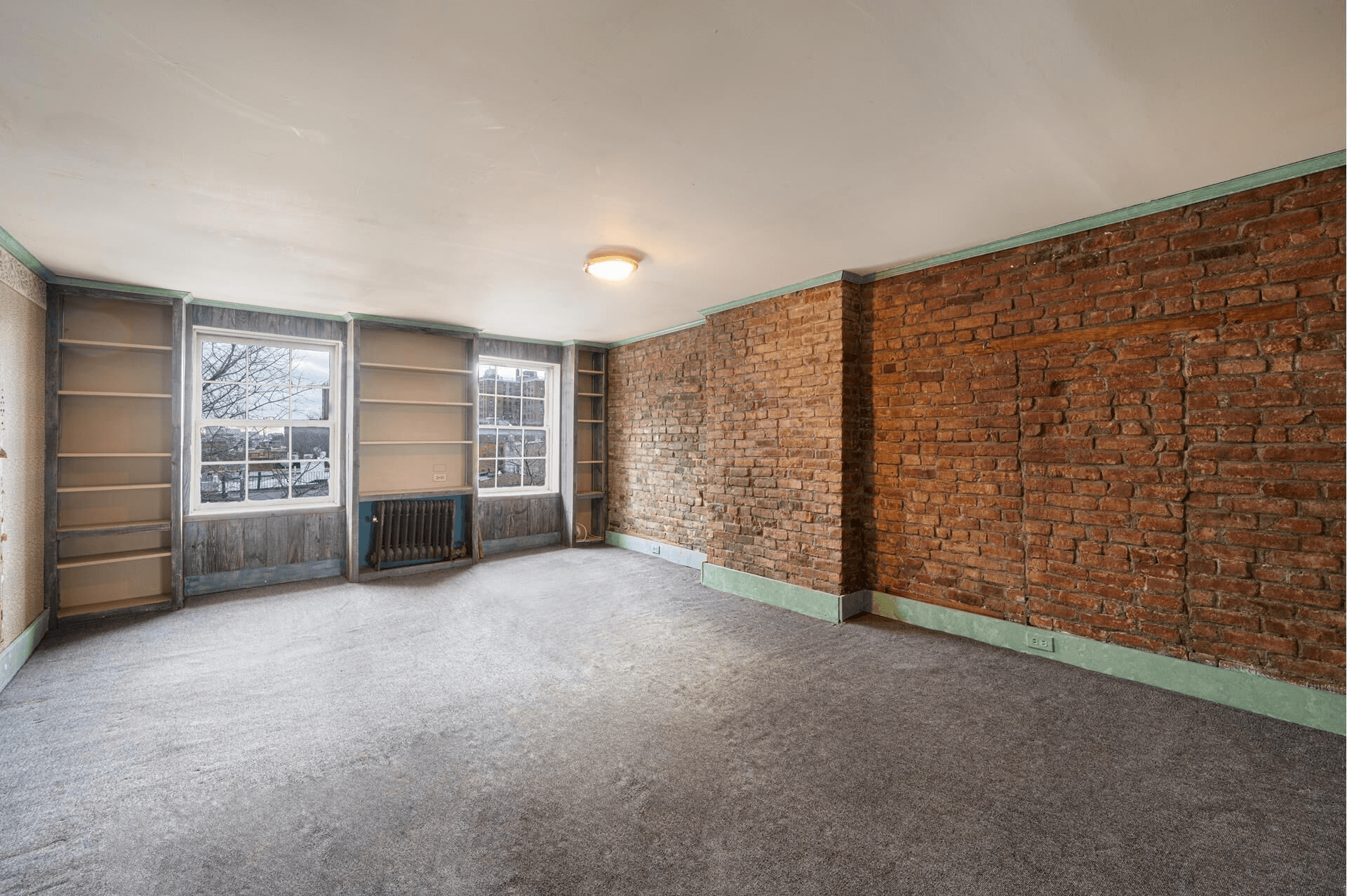 bedroom with bookshelves and exposed brick wall