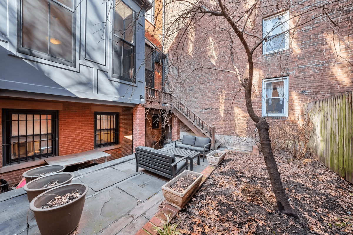 rear yard with stone patio and brick lined beds
