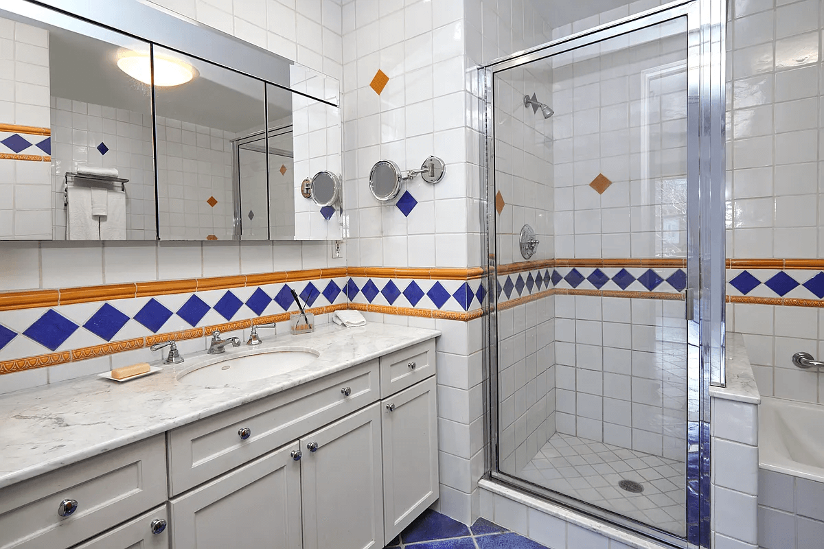 bathroom with white and blue tile and shower