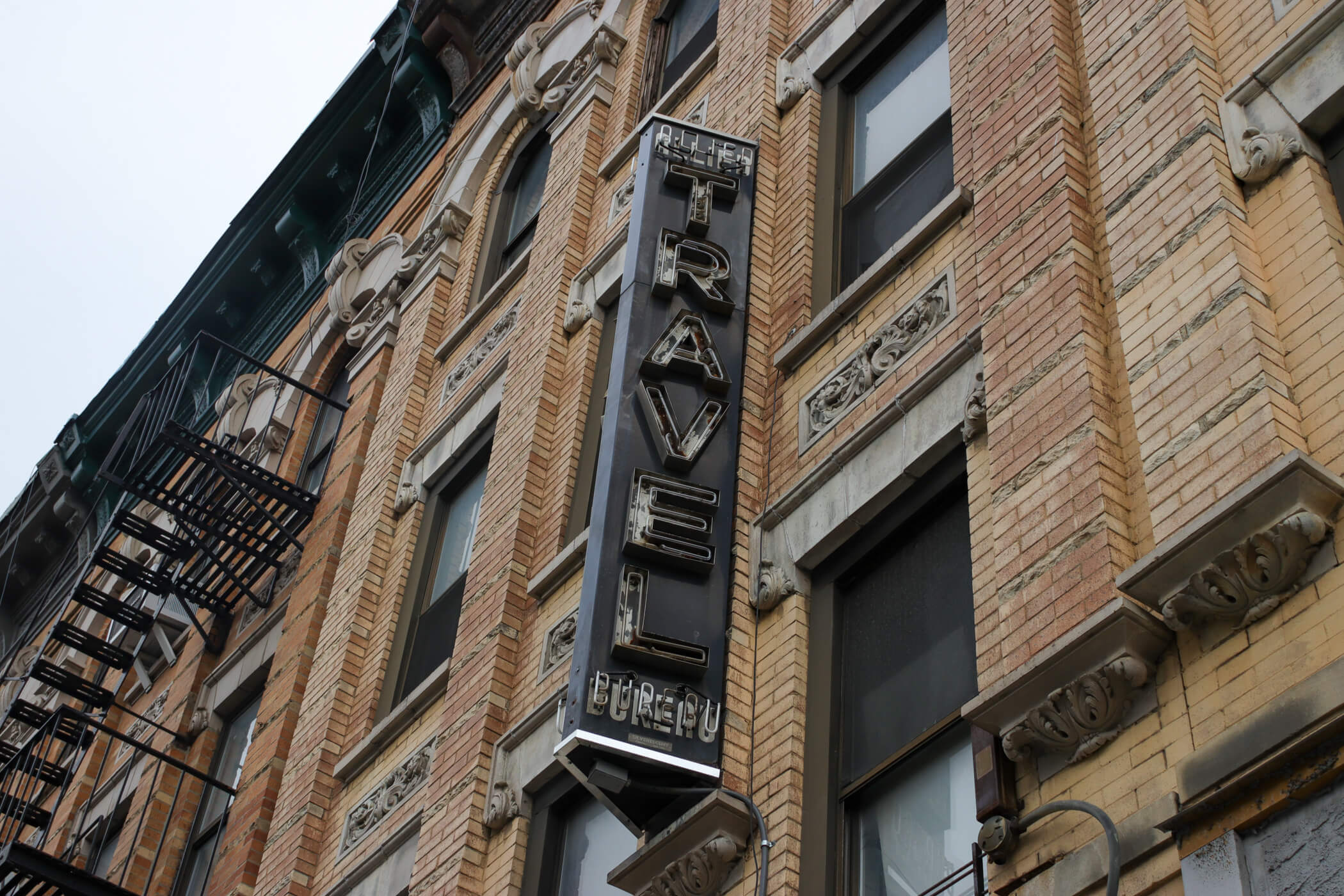 vintage travel sign on outside of brick building