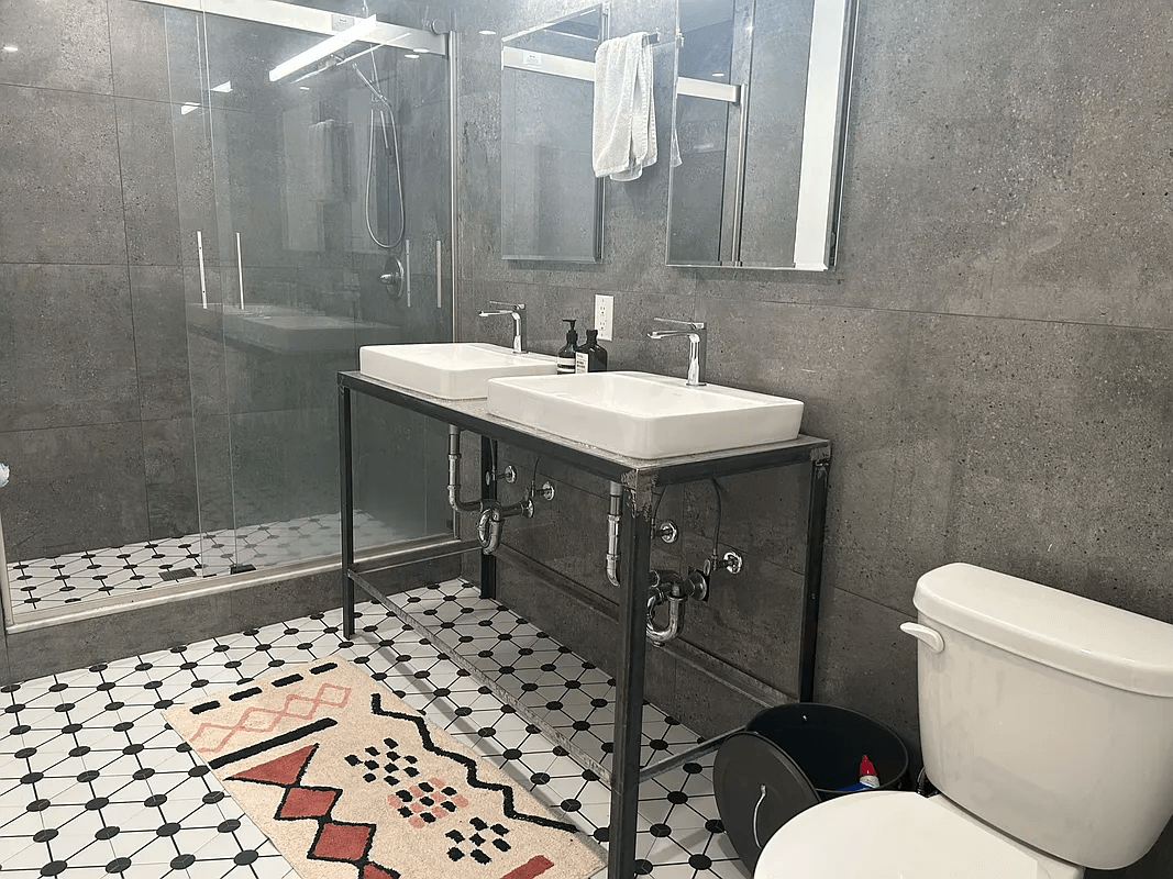 bathroom with double vanity and shower