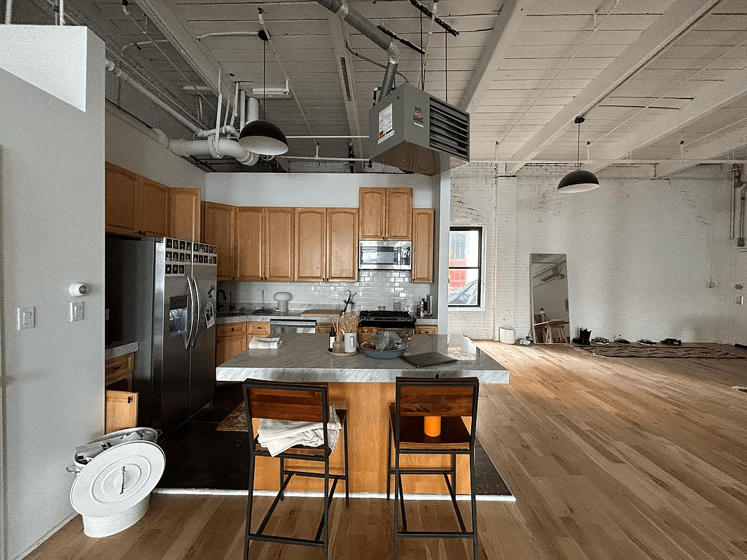 kitchen with wood cabinets and exposed pipes