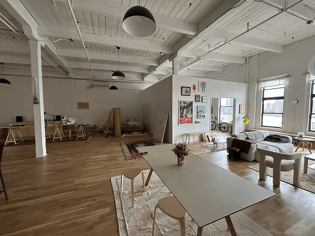 loft with beamed ceilings and wood floors