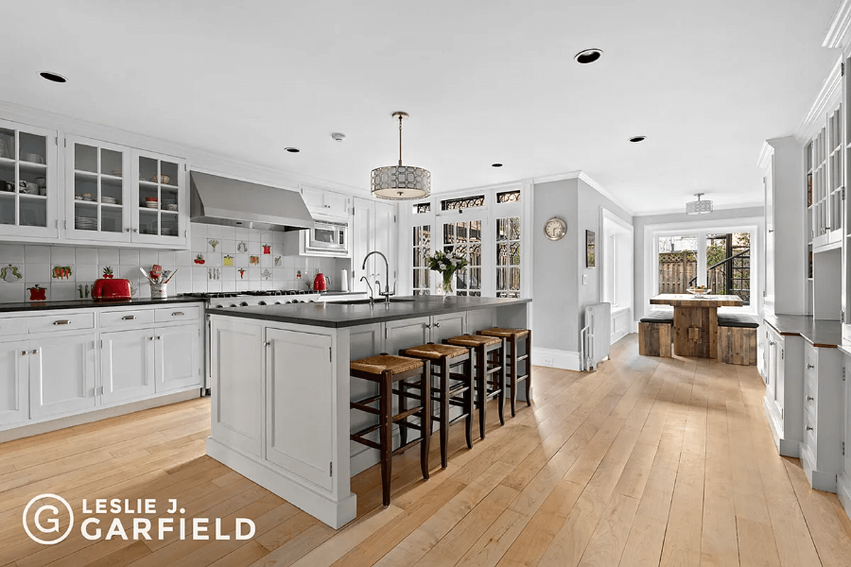 kitchen with white cabinets and vegetable accent tiles in backsplash