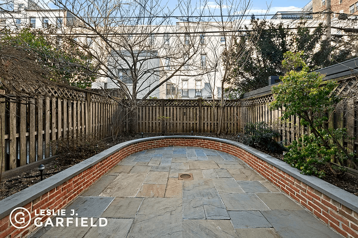 paved rear yard with planting beds