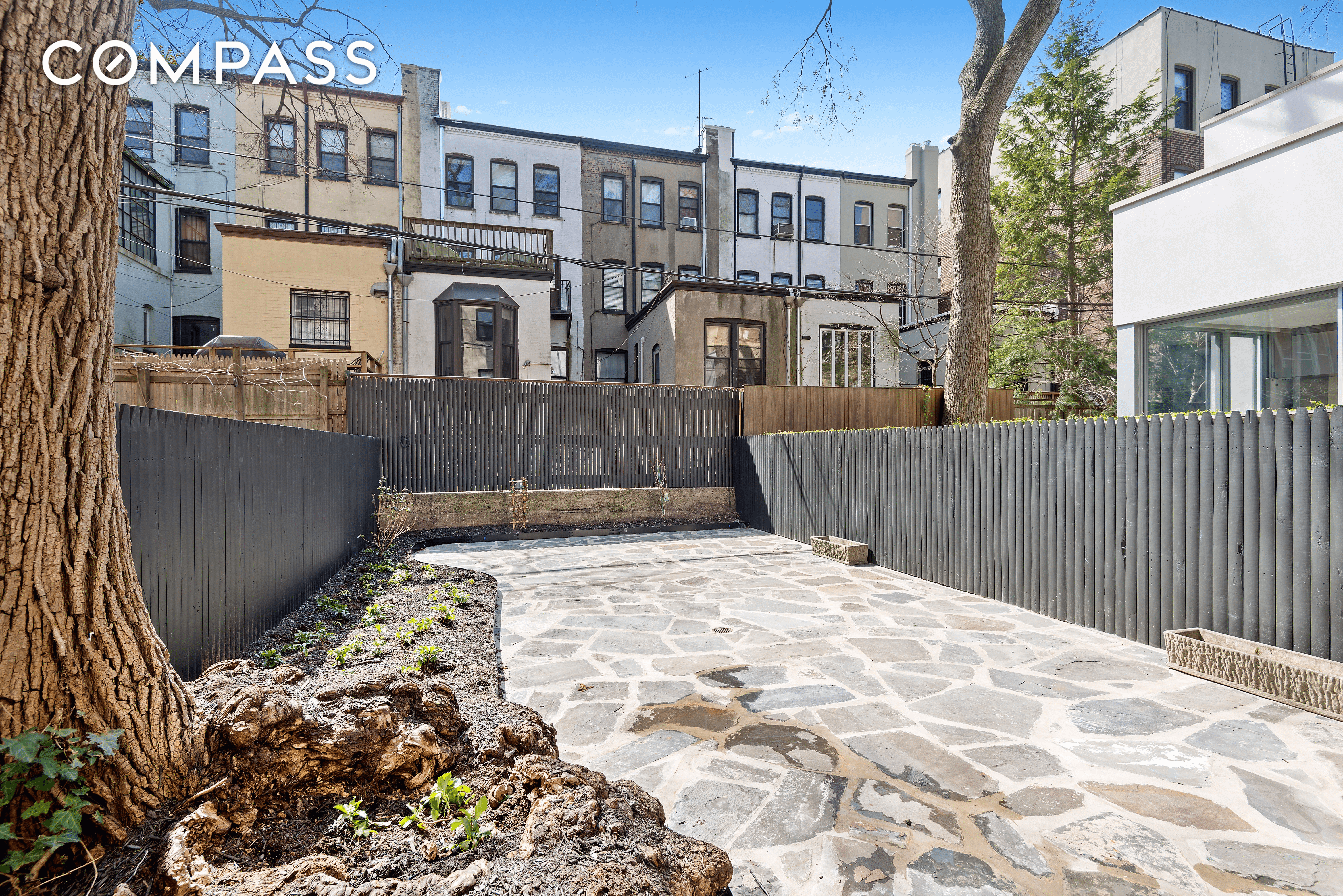 rear yard with stone patio and planting beds