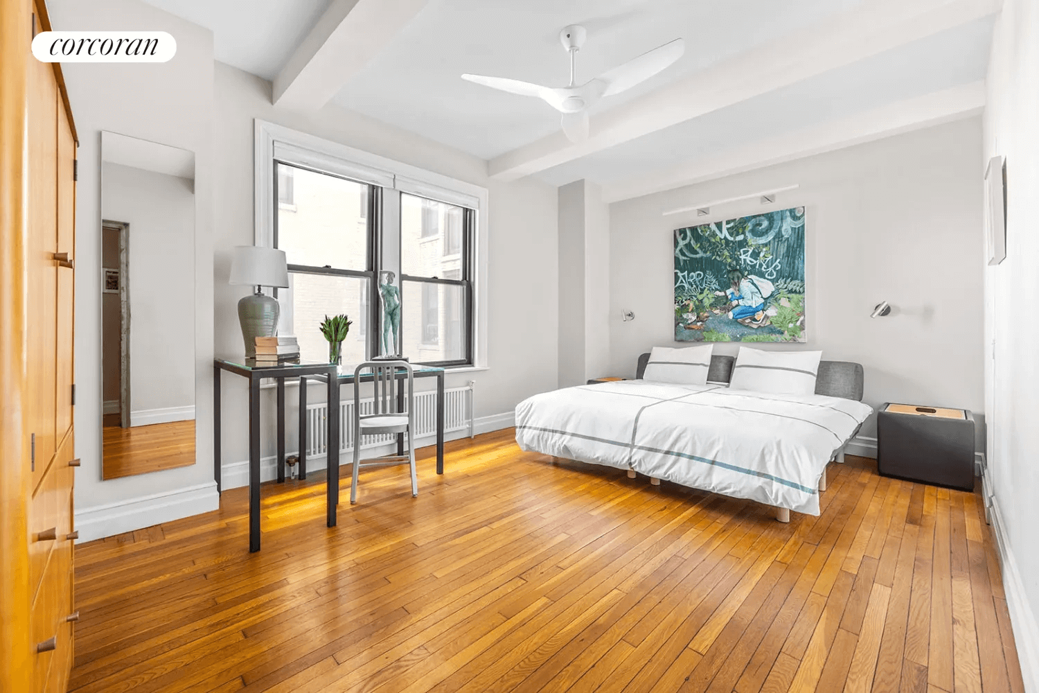 bedroom with beamed ceiling and wood floor