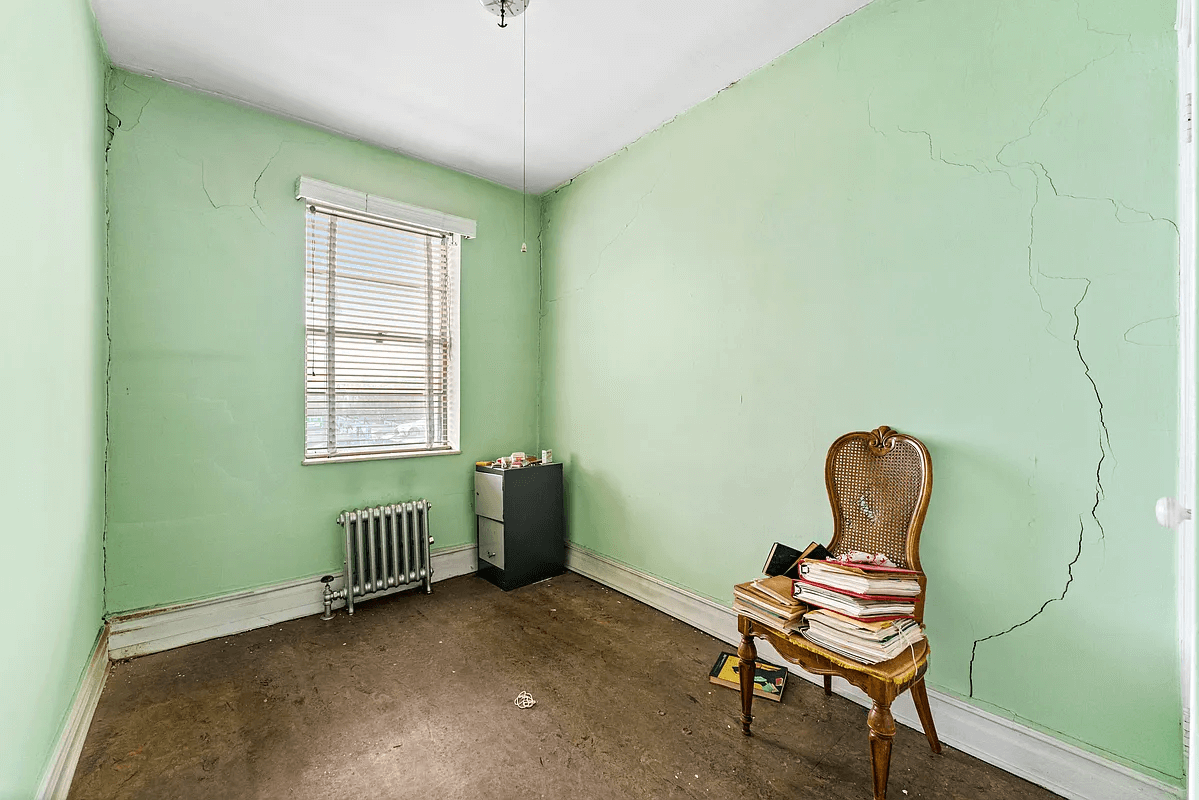 bedroom with green walls and crack in wall