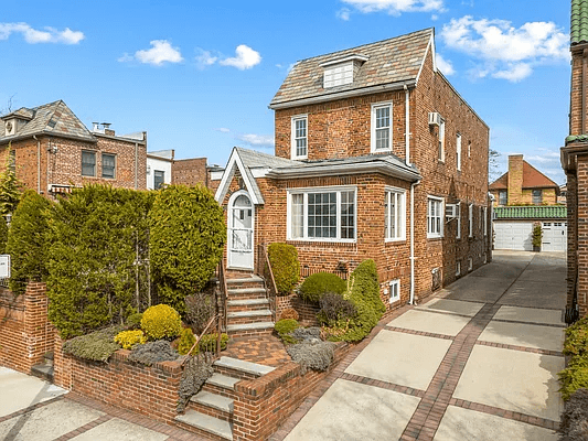 exterior of the brick house showing driveway and garage