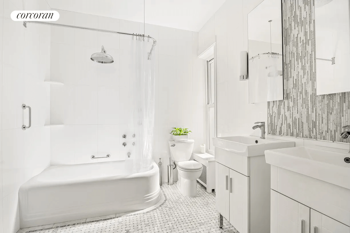 bathroom with dual sinks and white fixtures