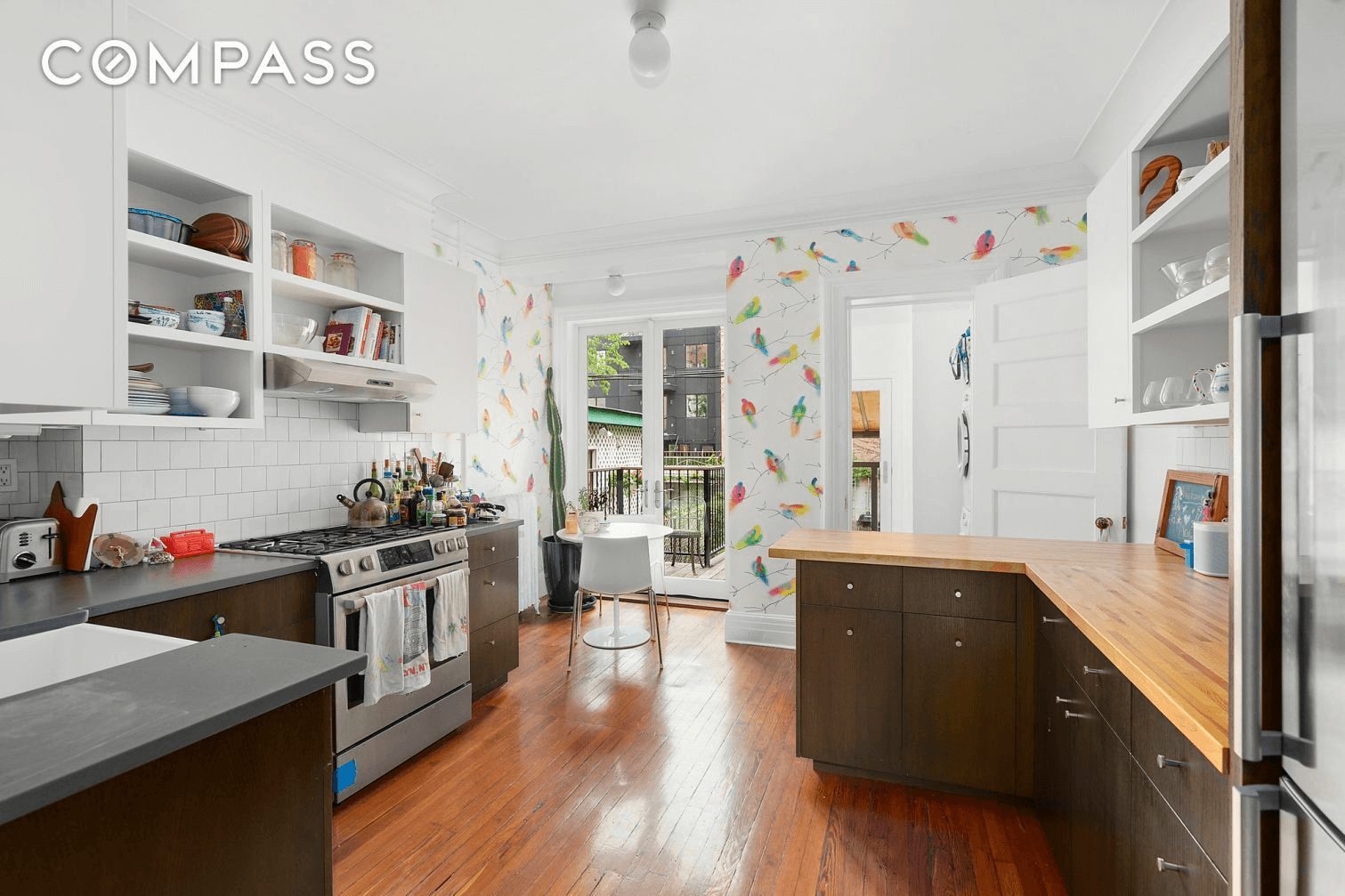 kitchen with bird wallpaper and dark cabinets
