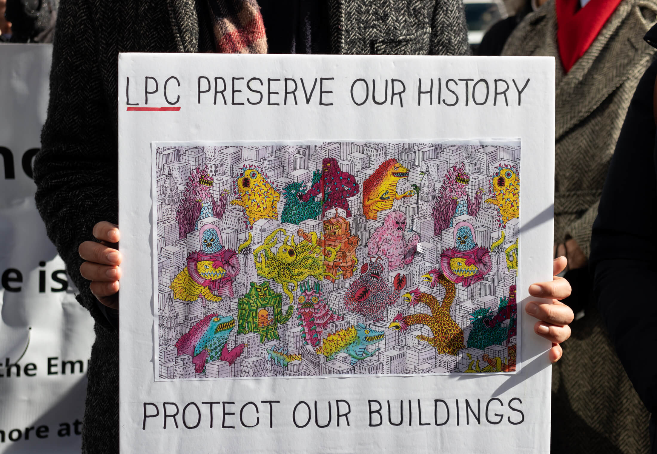 attendee holding a protect our buildings sign