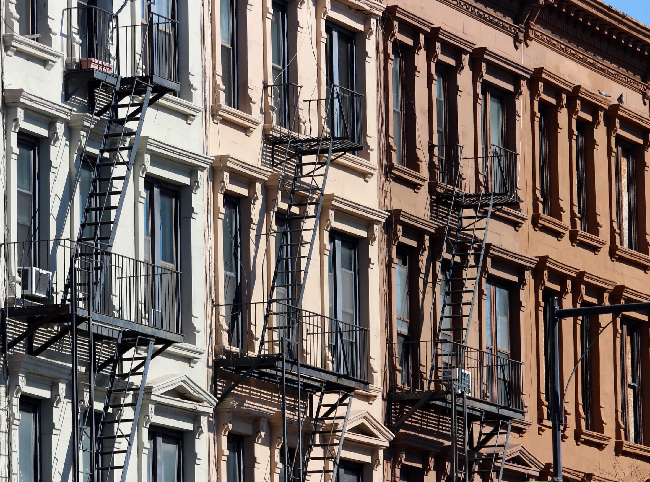 closeup of brownstone facades and fire escapes