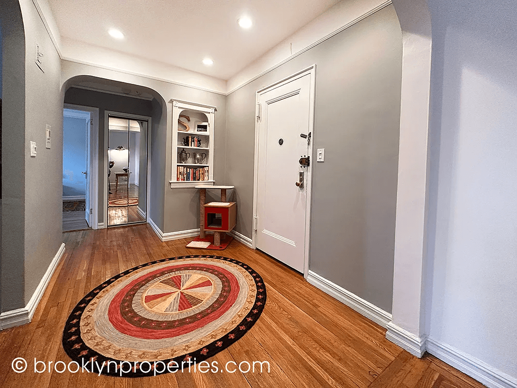 foyer with niche and wood floors