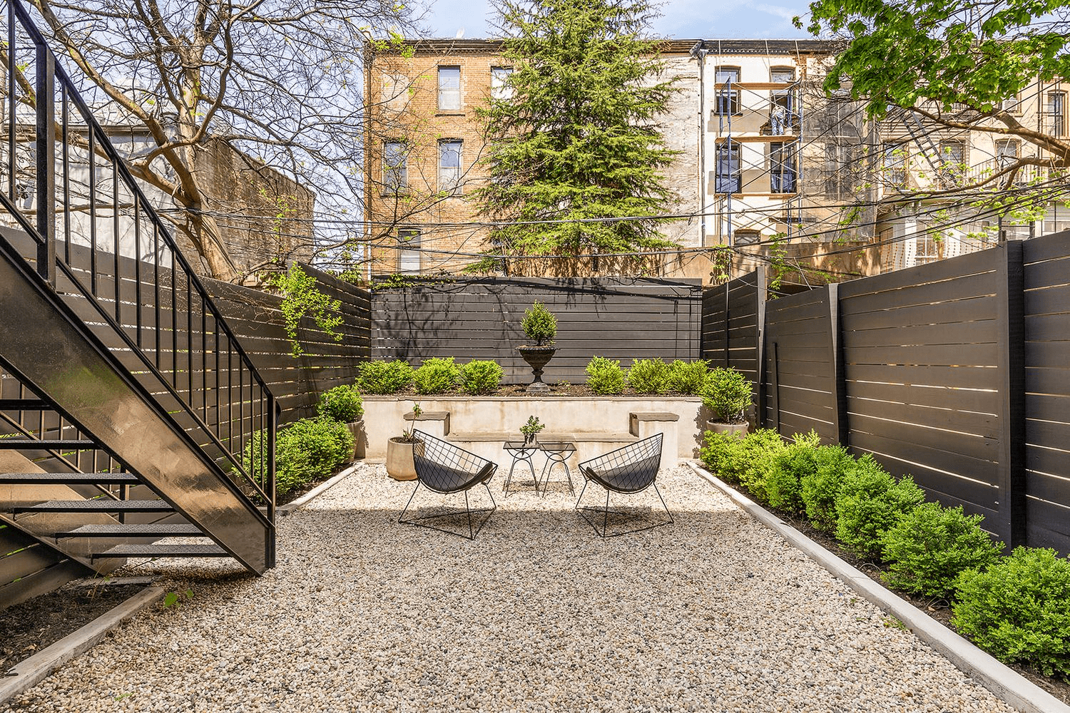 rear yard with planting beds and a gravel patio