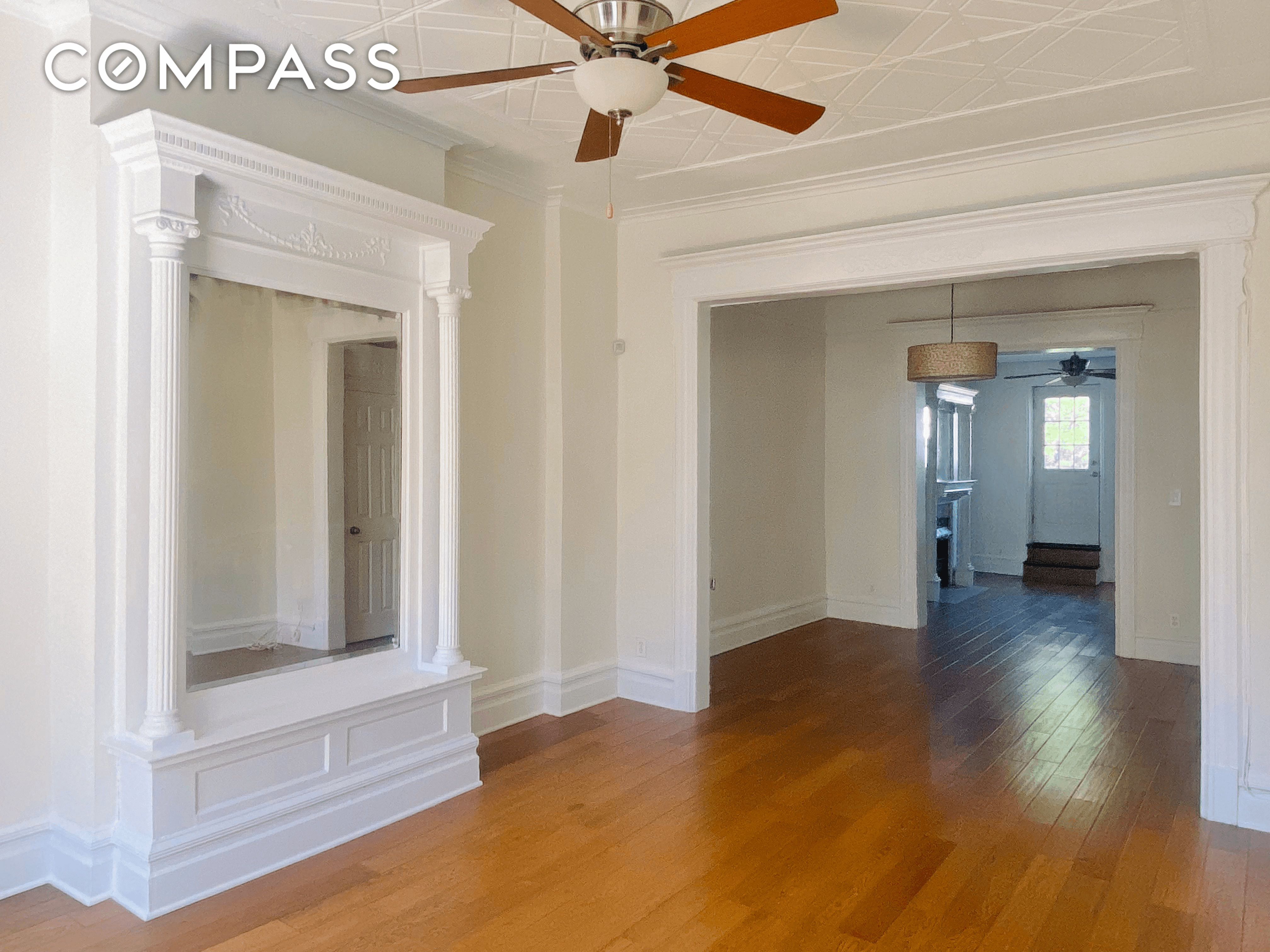 living room with pier mirror and ceiling fan