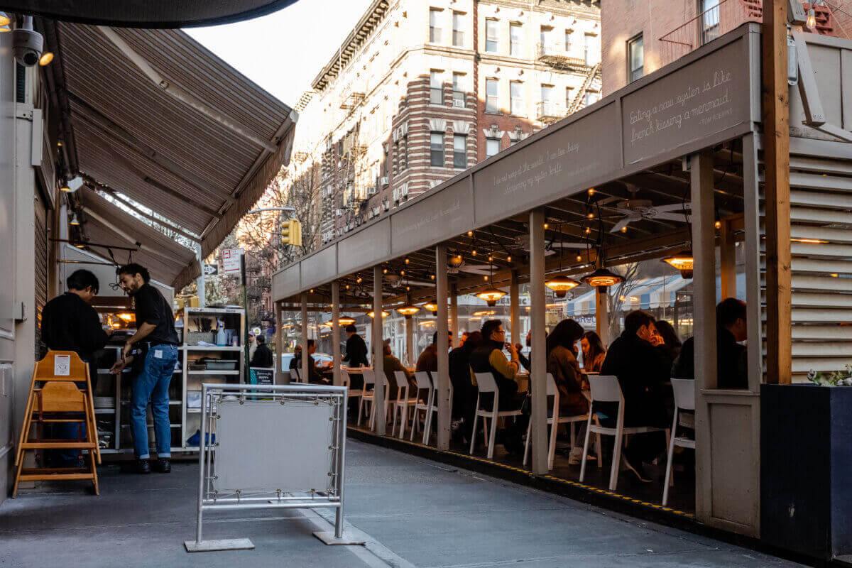 people eating in an outdoor dining shed