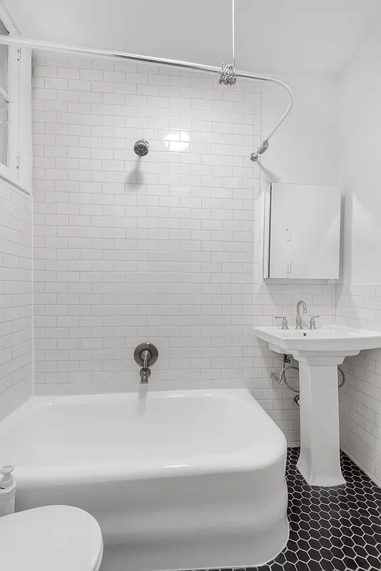 bathroom with black hex tile floor and white fixtures