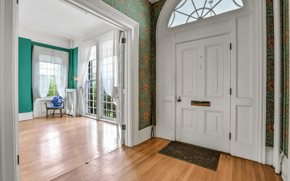 entry with wood floors and wallpaper