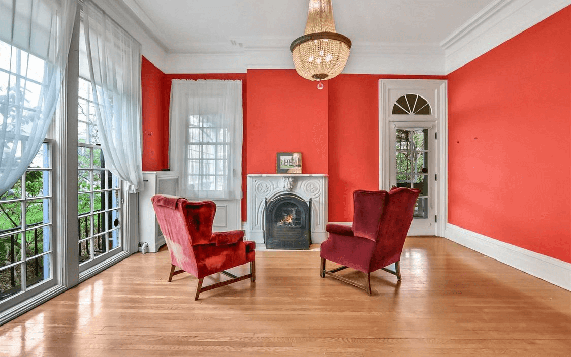 parlor with ceiling height windows and a mantel