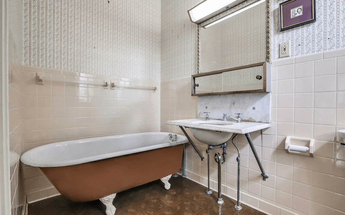 bathroom with claw foot tub and marble sink