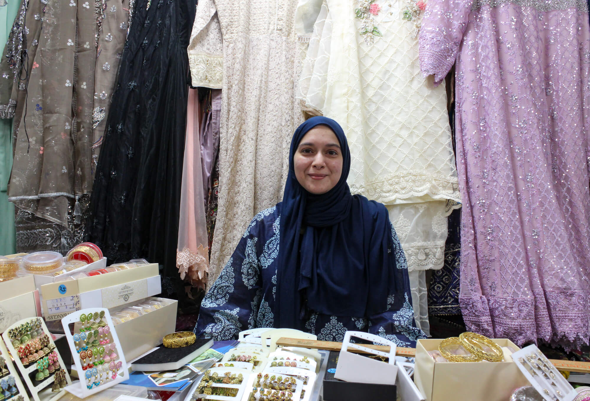 woman behind a store counter with jewelry on display