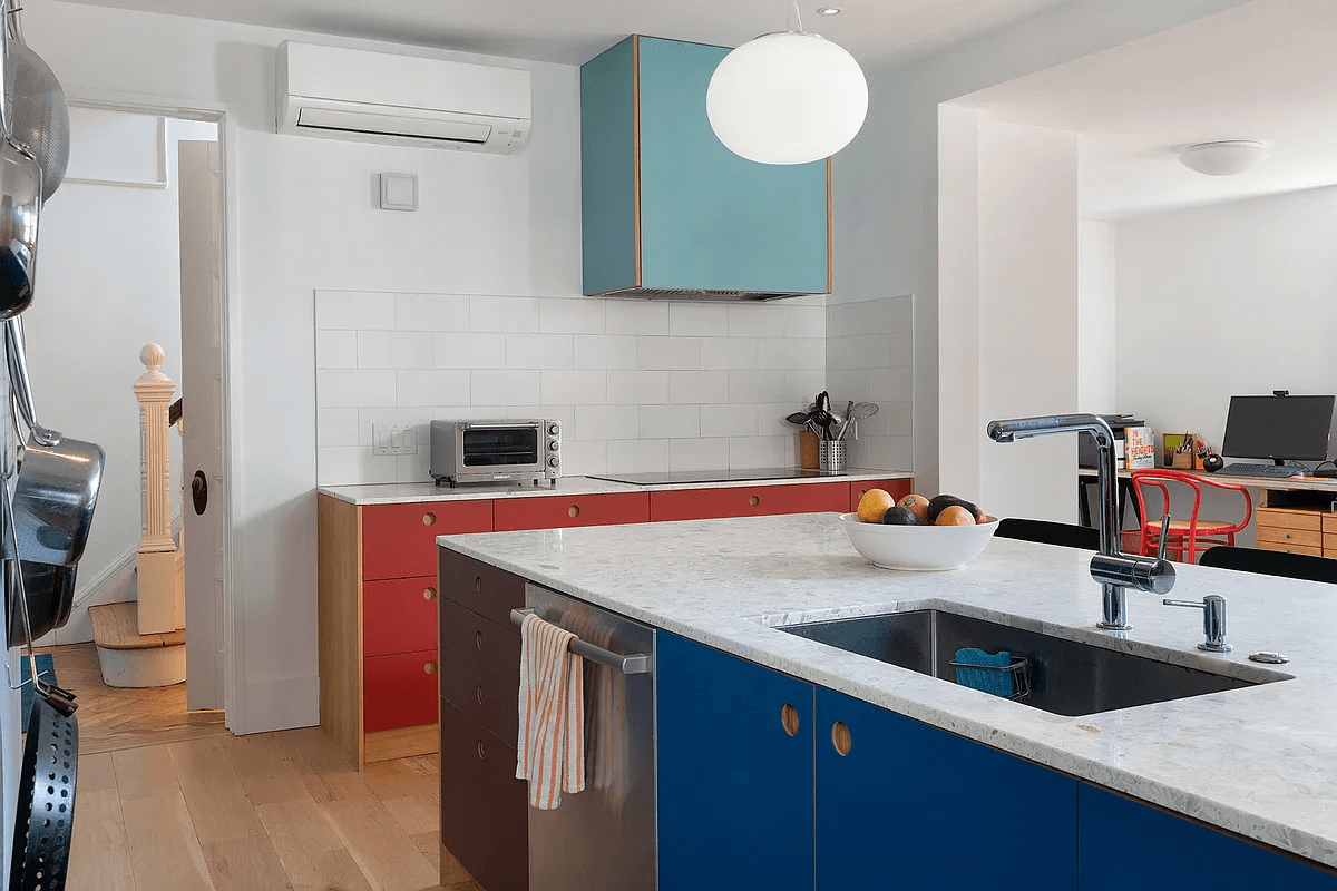 kitchen with white wall tile and cabinets in red and blue