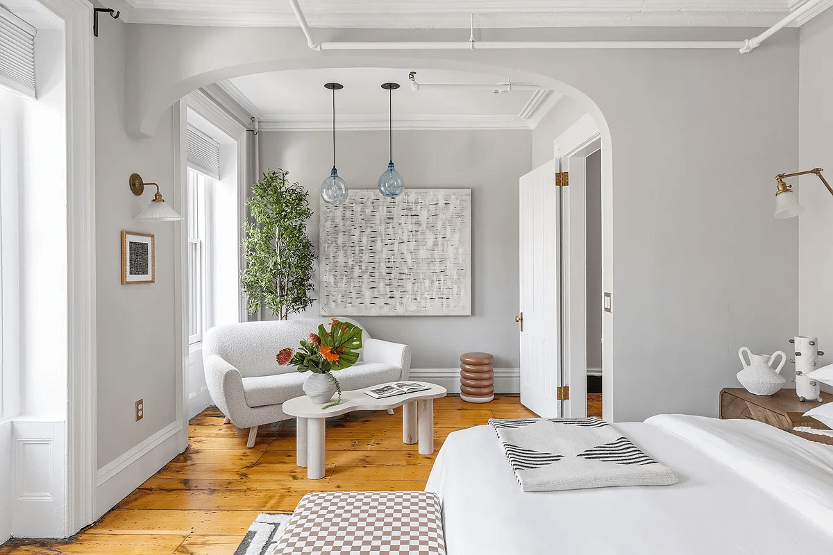 bedroom with wide floorboards and a niche