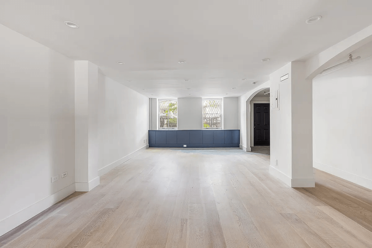garden level apartment with pale floors and recessed lighting