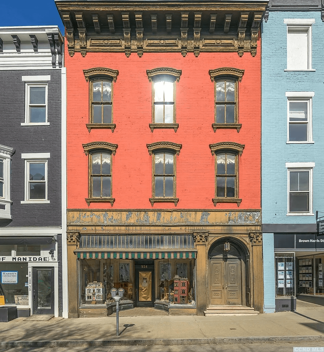 full view of exterior of red painted brick building