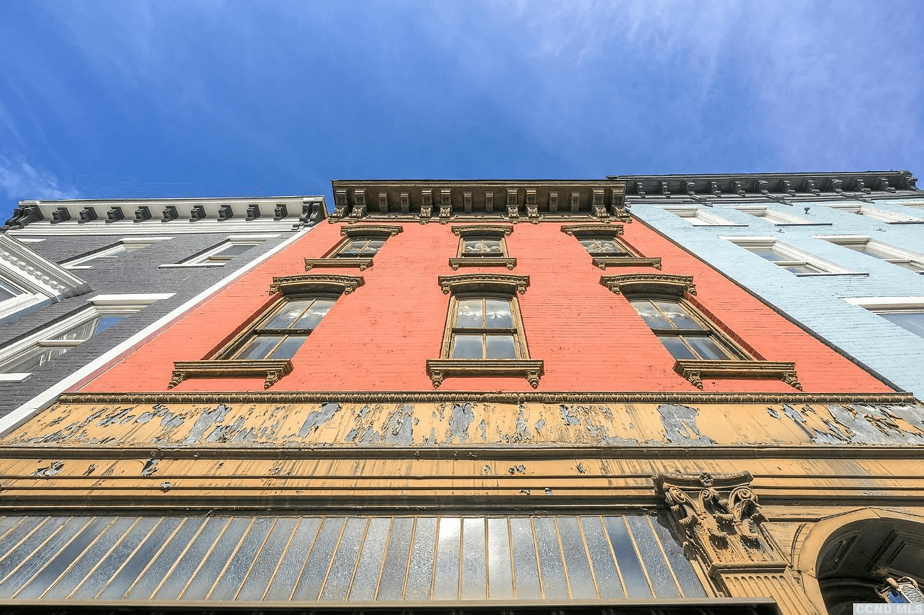 view looking up at brick building and its bracketed cornice
