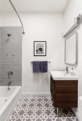 batroom with wood vanity and gray shower tile